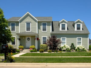 Two-story family home with light green siding