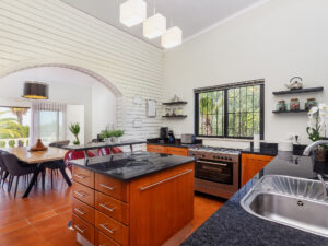 Remodeled kitchen with white brick walls and cherry cabinets, flooring