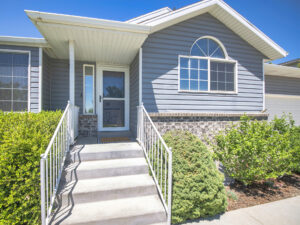 Quaint home with steps leading up to the front and cornflower blue siding and white trim