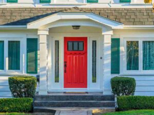 A bright red front door on a house, showcasing Strom Doors in El Reno, OK