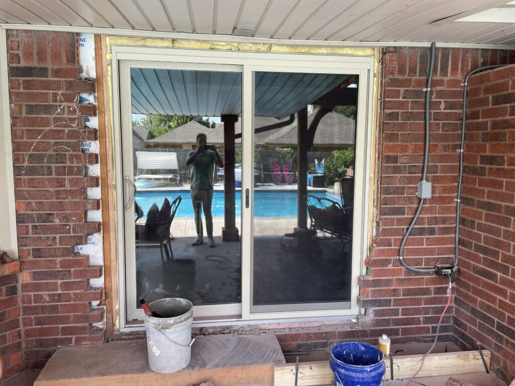 Sliding patio door installed during construction before exterior brick and trim repairs