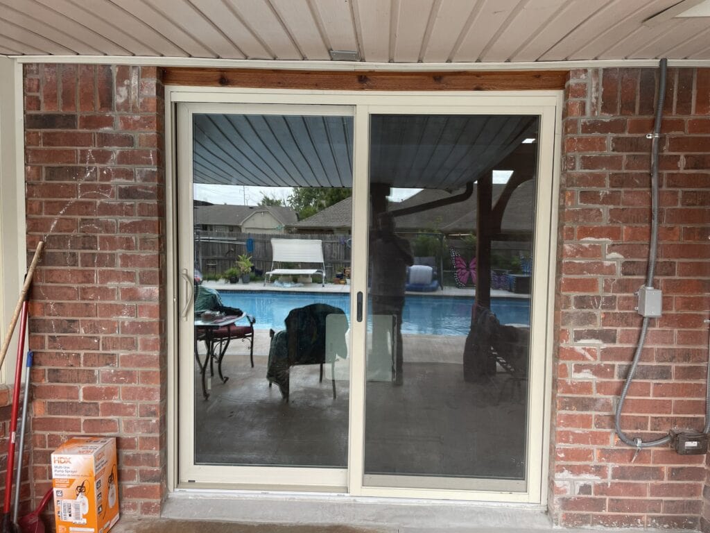 Finished sliding patio door replacement with backyard patio and pool access